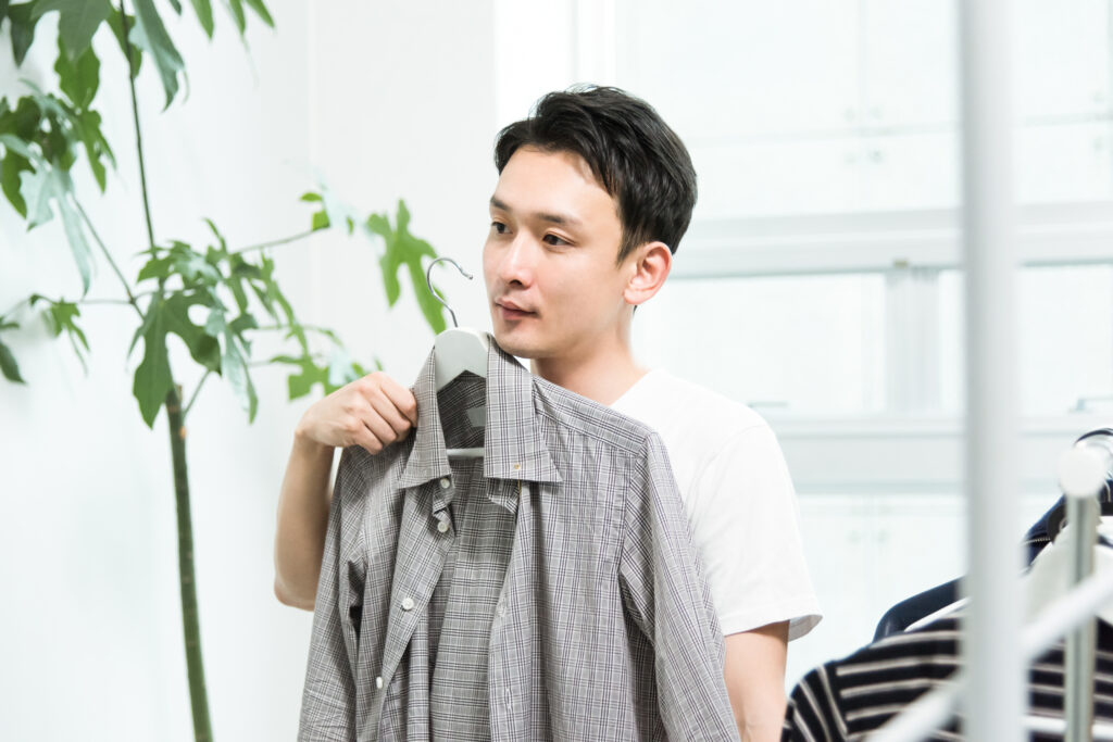 ナベシャツを着用し服を選ぶ男性